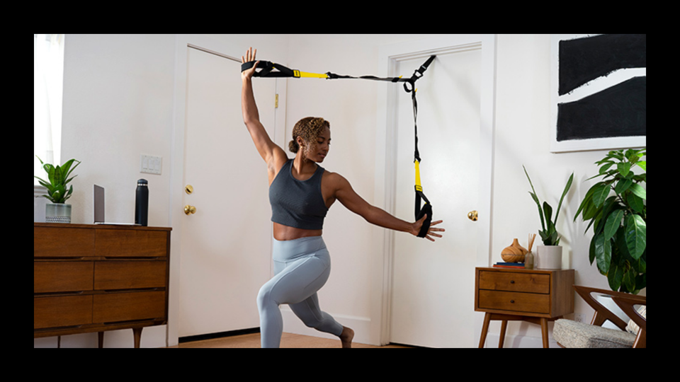 A woman using the TRX Pro 3 home gym