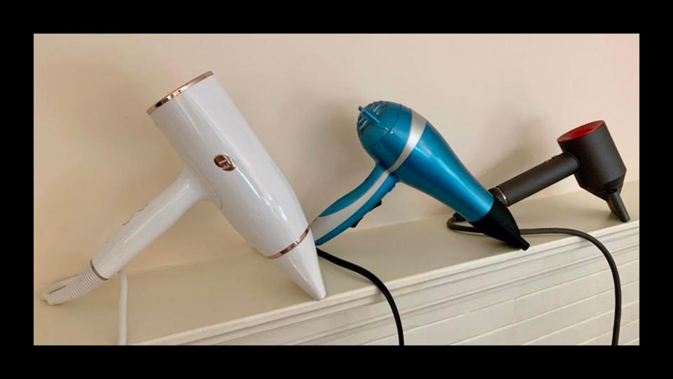 The three best hair dryers standing upright on a shelf