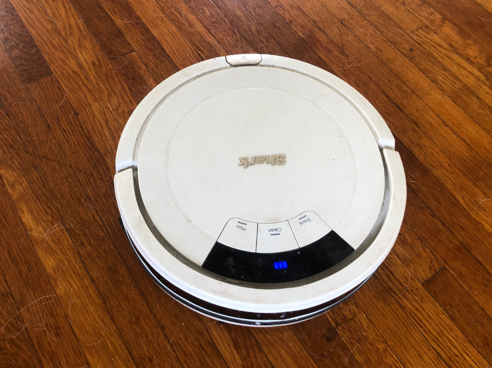 photo from claire epting of white shark ion robot vacuum on hardwood cleaning dog hair