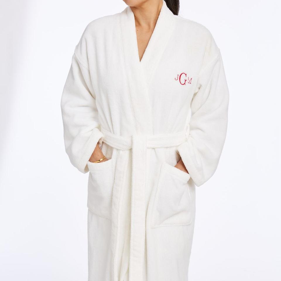 Folded white robe with the initials monogrammed on the left chest side