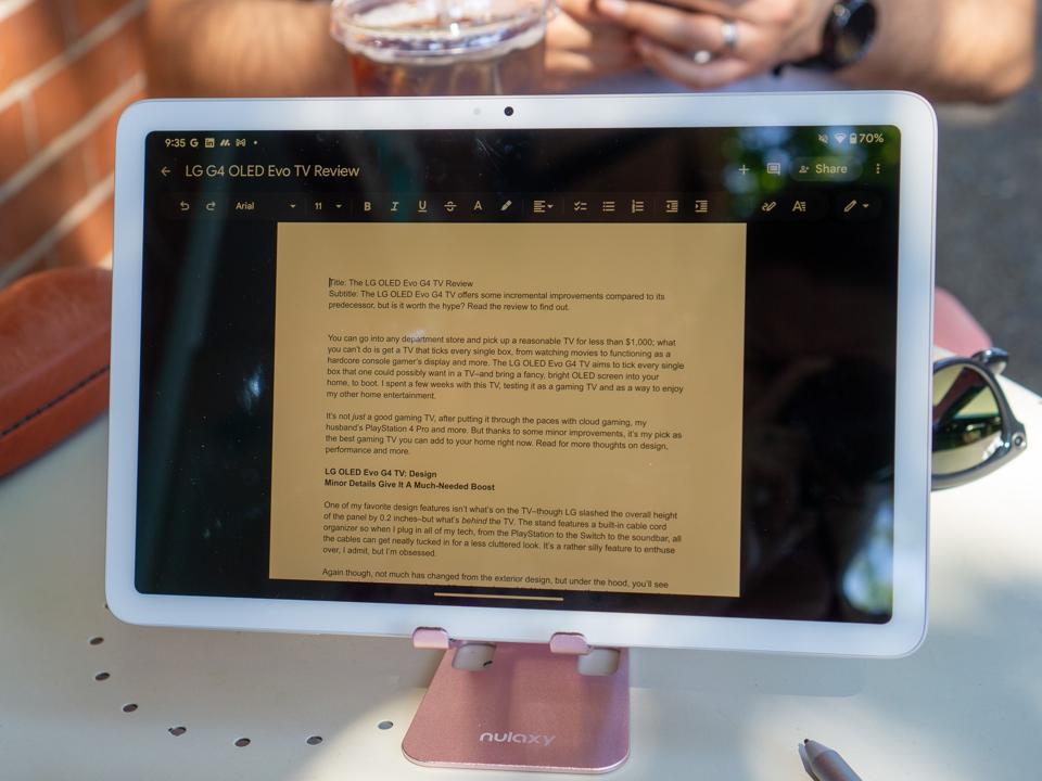 The author's Google Pixel 2 Tablet on a pink stand with a Google Doc displayed on the screen.