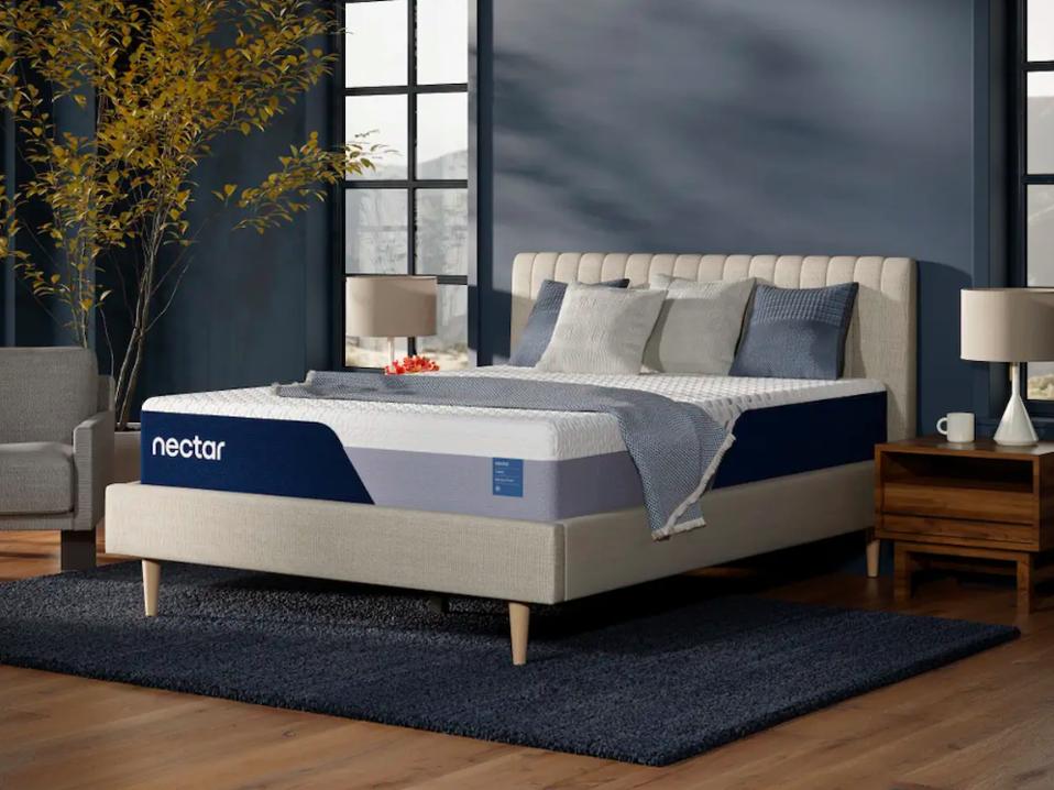 The Nectar Classic Memory Foam Mattress on a white upholstered bed frame. 