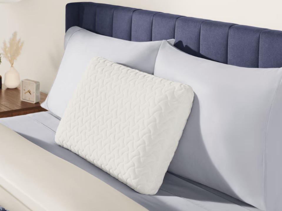 photo of tempur-cloud pillow against two regular pillows on bed in bedroom