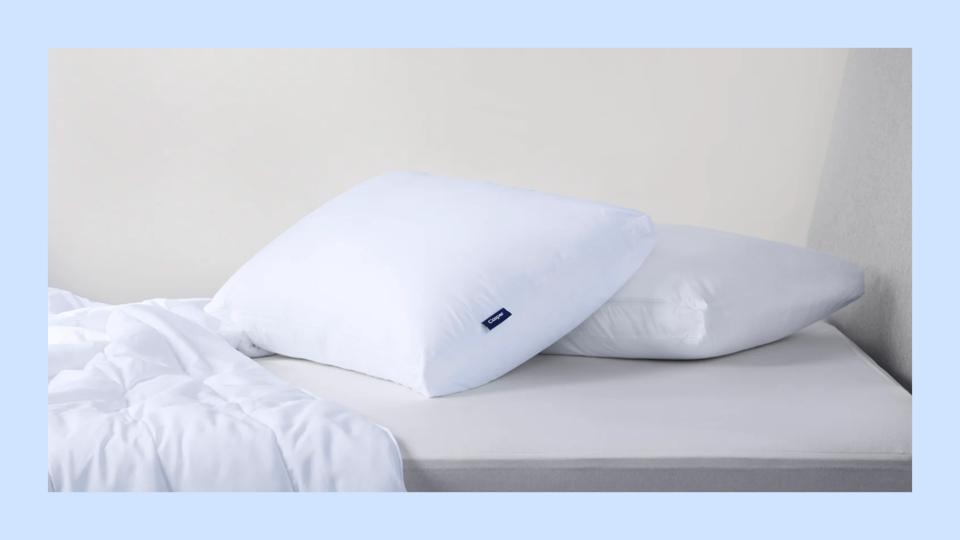 Two Casper pillows on a mattress against a blue background.