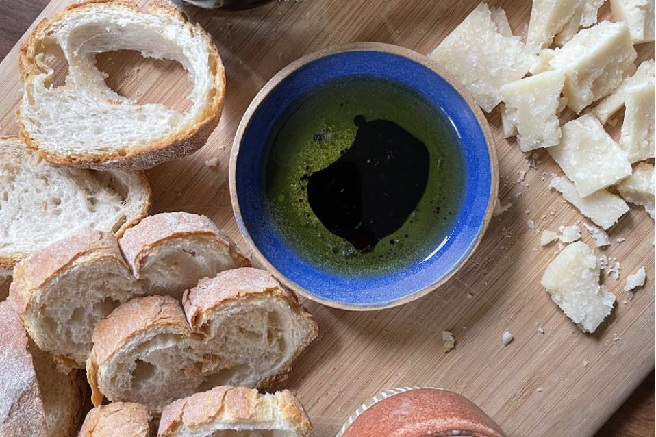 The La Cà dal Non Aceto Balsamico Tradizionale di Modena D.O.P. suspended in olive oil, alongside bread and parmesan.