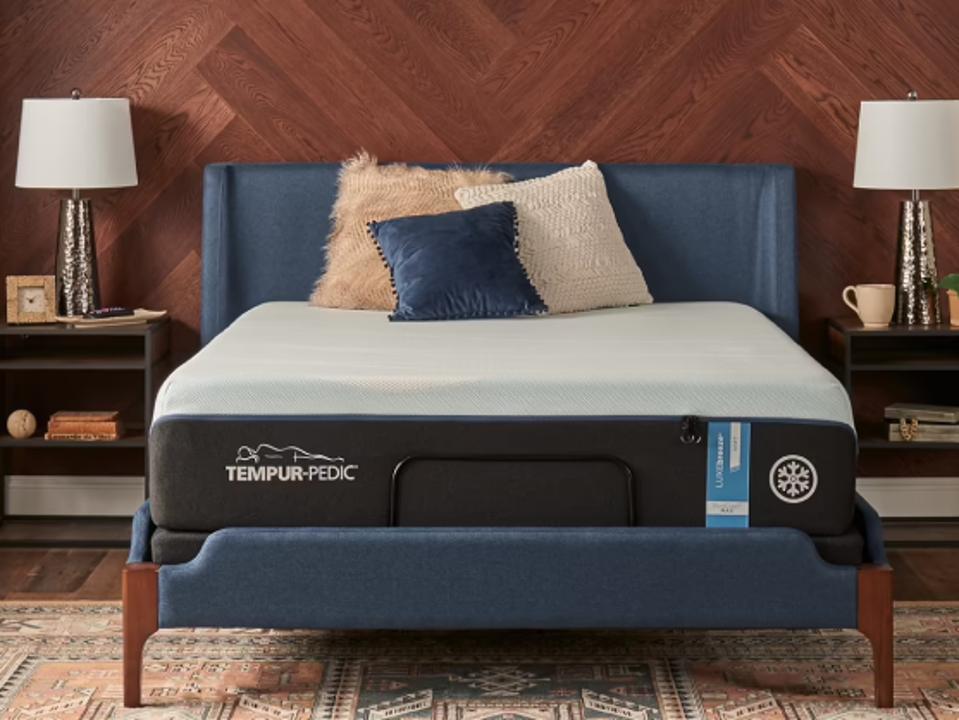 The Tempur-Breeze Memory Foam Mattress on a blue bed frame with pillows in a bedroom