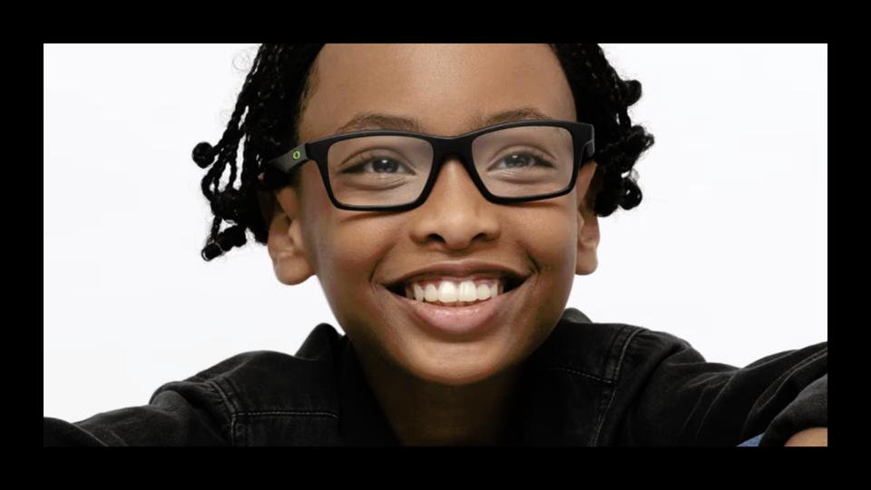 Smiling child wearing a pair of glasses with black frames from GlassesUSA