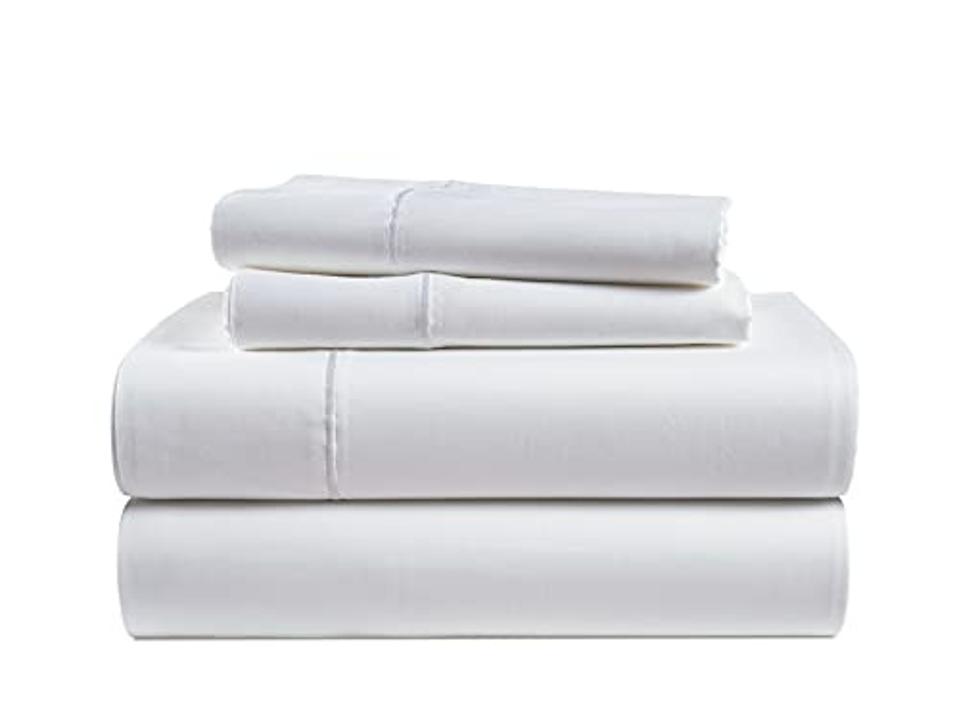 Stack of sheets with two pillowcases on top on a white background