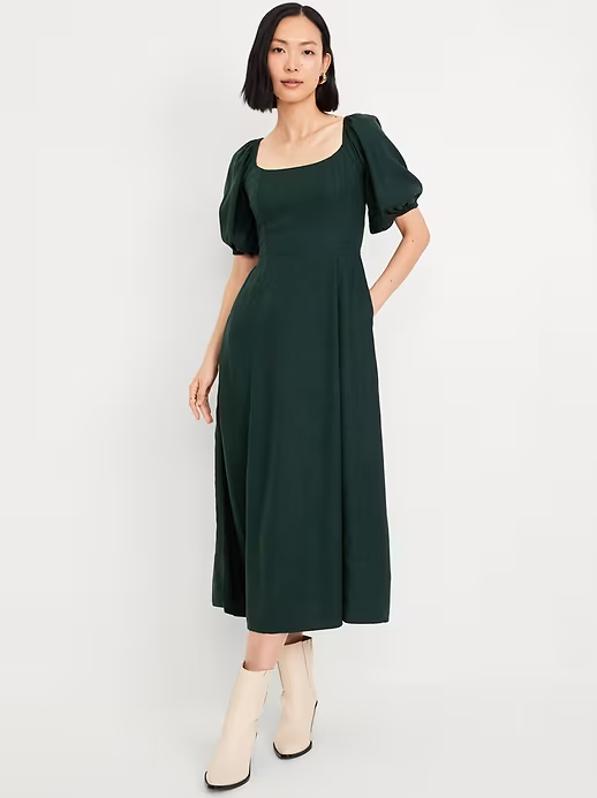 Woman wears green midi-dress with puff sleeves and white heeled boots