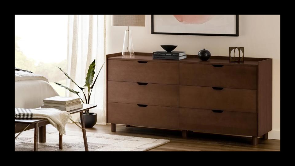 A dark wood dresser featured in a stylish and modern bedroom. 