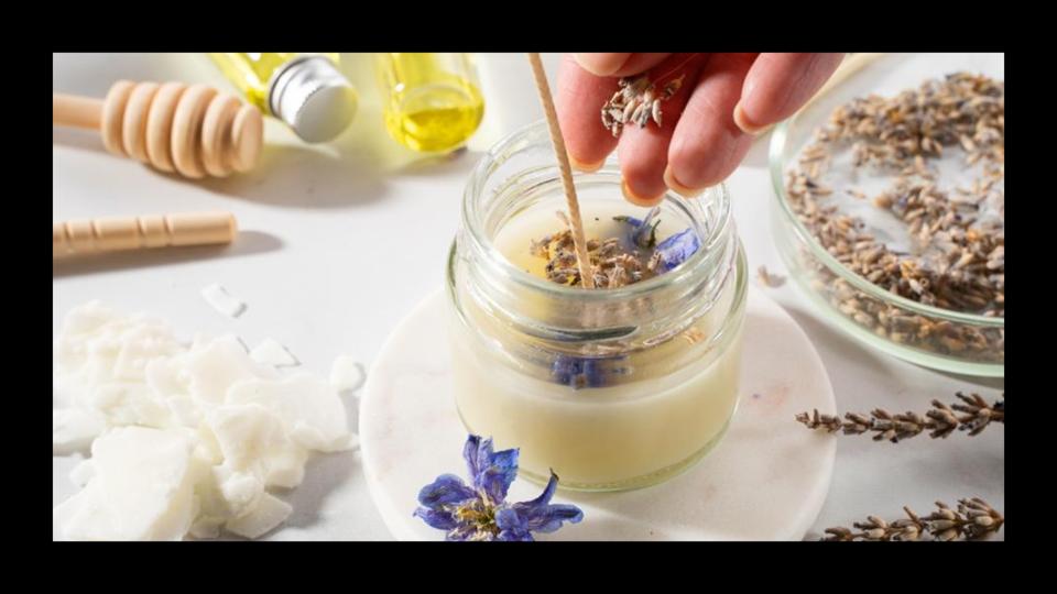 Image of a hand creating a wax candle.