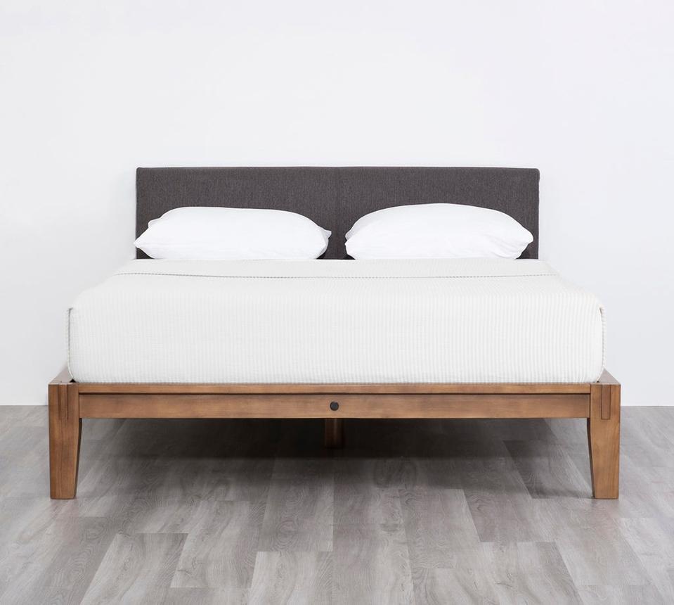 Thuma bed frame with two pillows against white wall.