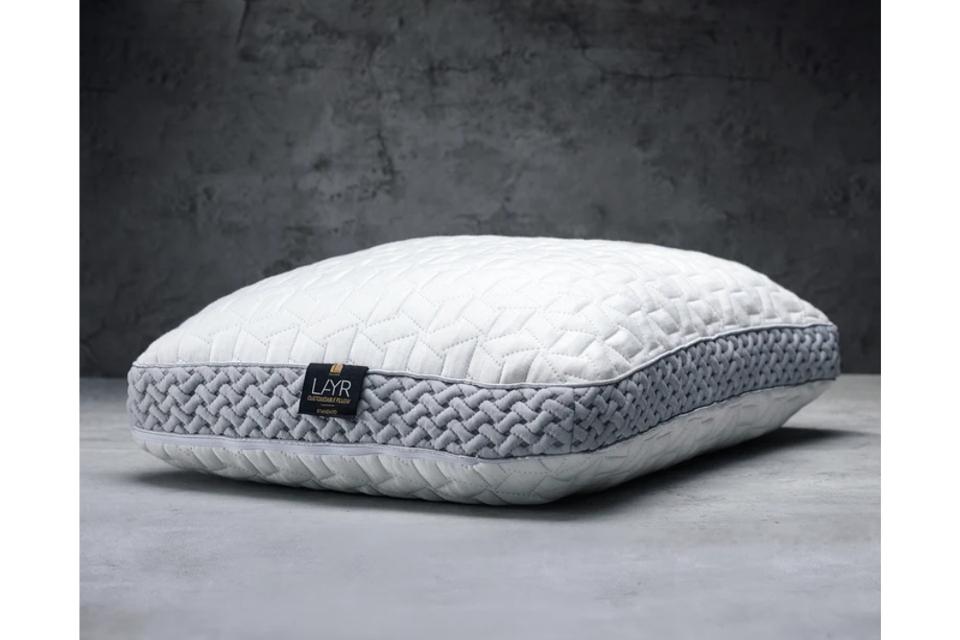 Luxome Layr Customizable Pillow on a gray surface in front of a dark gray background