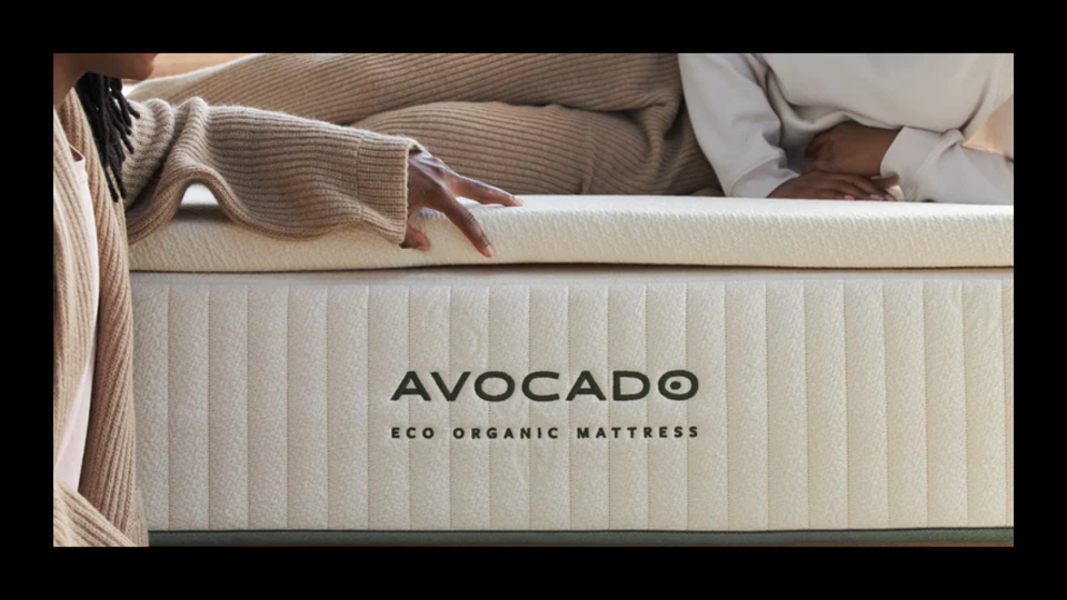 Two black women on The Avocado Eco Organic Mattress Topper above an Avocado mattress