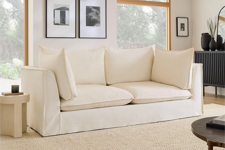 The West Elm Bleecker Slipcover Sofa in a living room with a tan rug