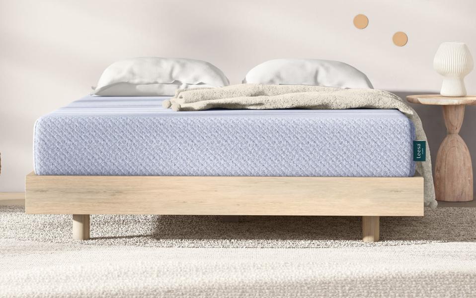 Lifestyle image of the Leesa Studio mattress on a wood platform bed frame. 