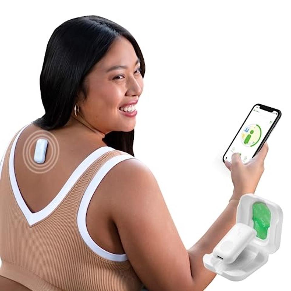 A woman smiling while wearing the Upright Go 2 Smart Posture Corrector