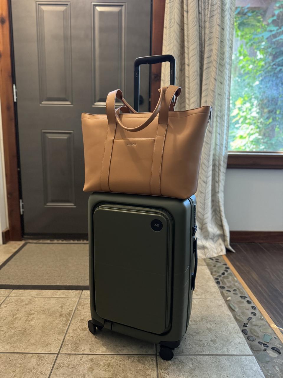 A suitcase with a trolley sleeve bag attached.