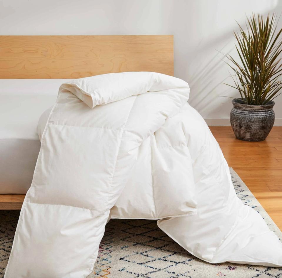 Brooklinen Down Alternative Comforter on the end of a platform bed in sunny bedroom.