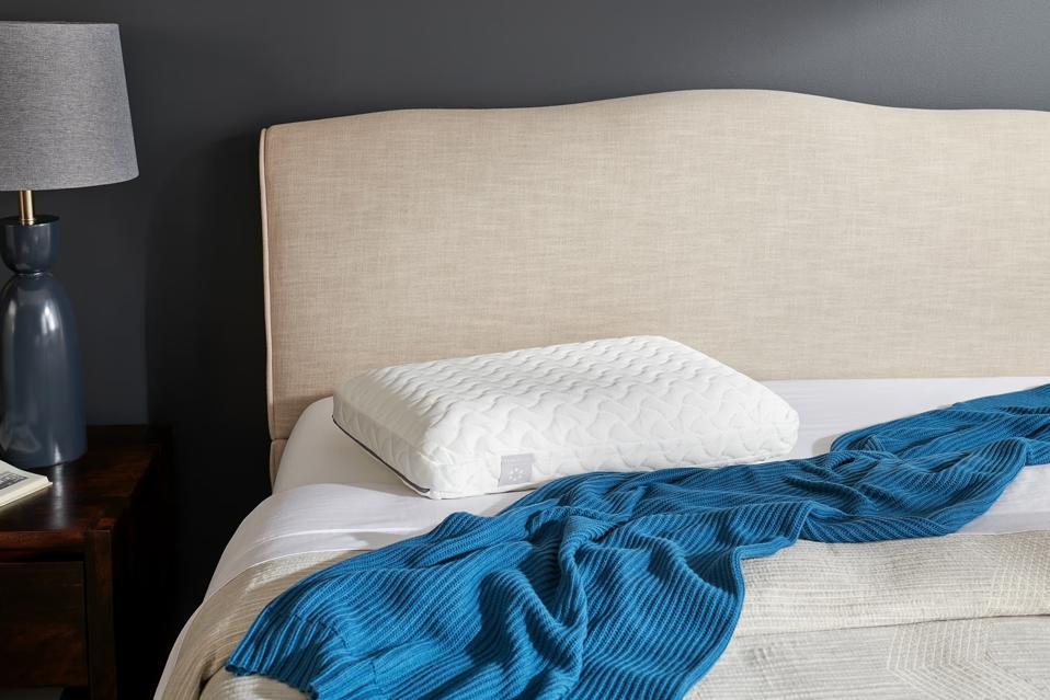 The TEMPUR-Cloud Pillow on a mattress with a blue blanket.