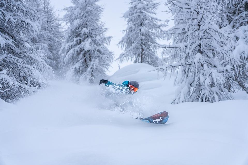 A man snowboarding in deep snow on a mountain