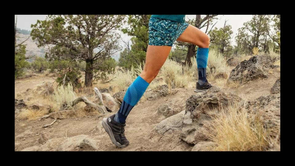 A woman wearing a pair of blue Smartwool compression socks