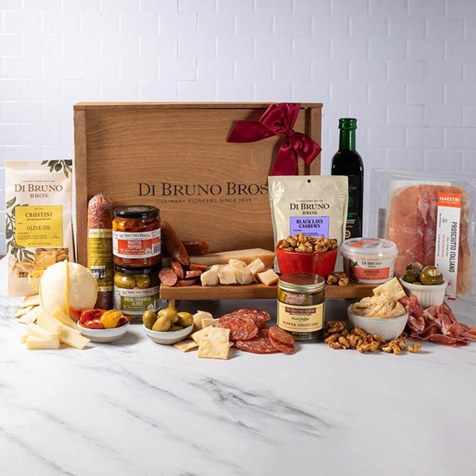 di burno bros The Italian Market Crate w/ cheeses meats olives crackers nuts crostini against white tile wall