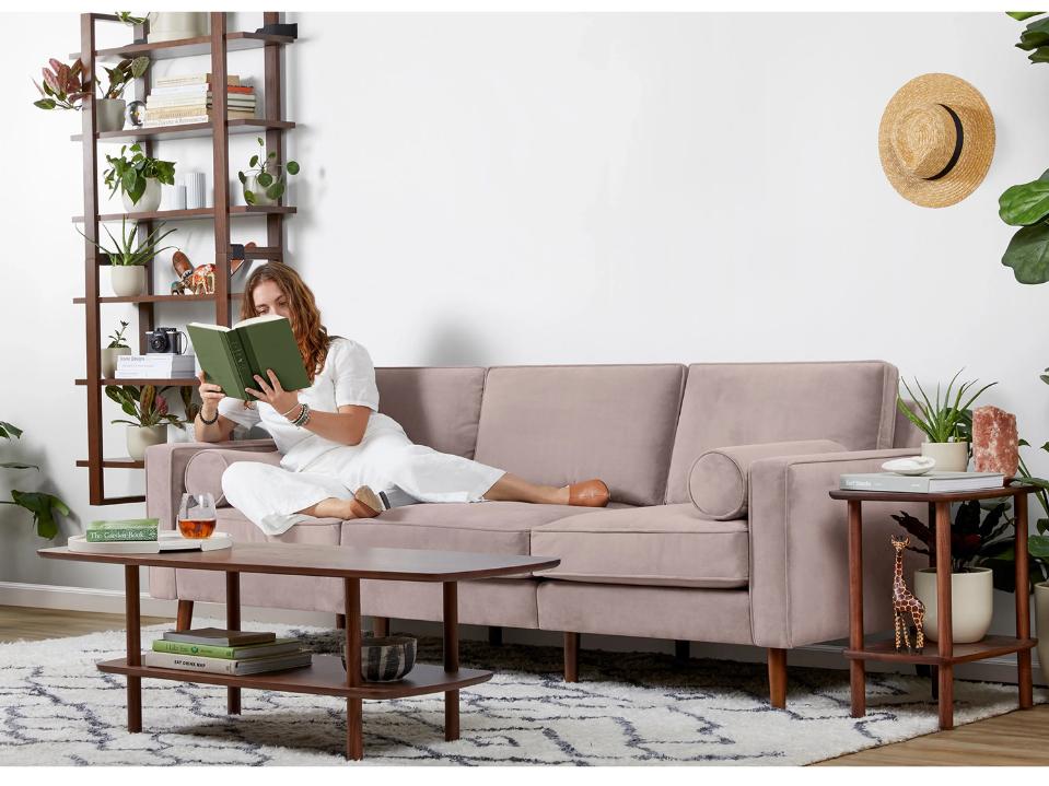 photo of nomad velvet burrow couch in light pink w/ woman reading in spacious daylit living rm