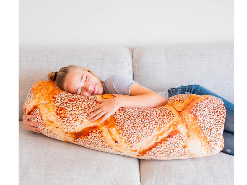 woman hugging a pillow that looks like baguette