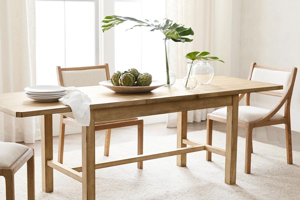 The Mateo Extending Dining Table in natural finish, styled in a dining room on an ivory rug