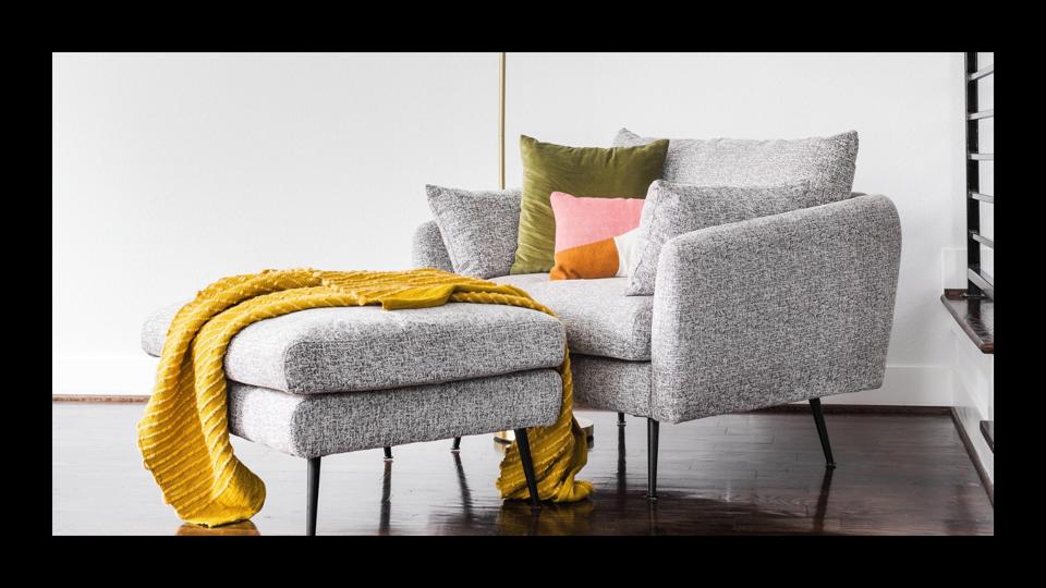 The Albany Park Park Armchair and ottoman featured in a modern living room. 