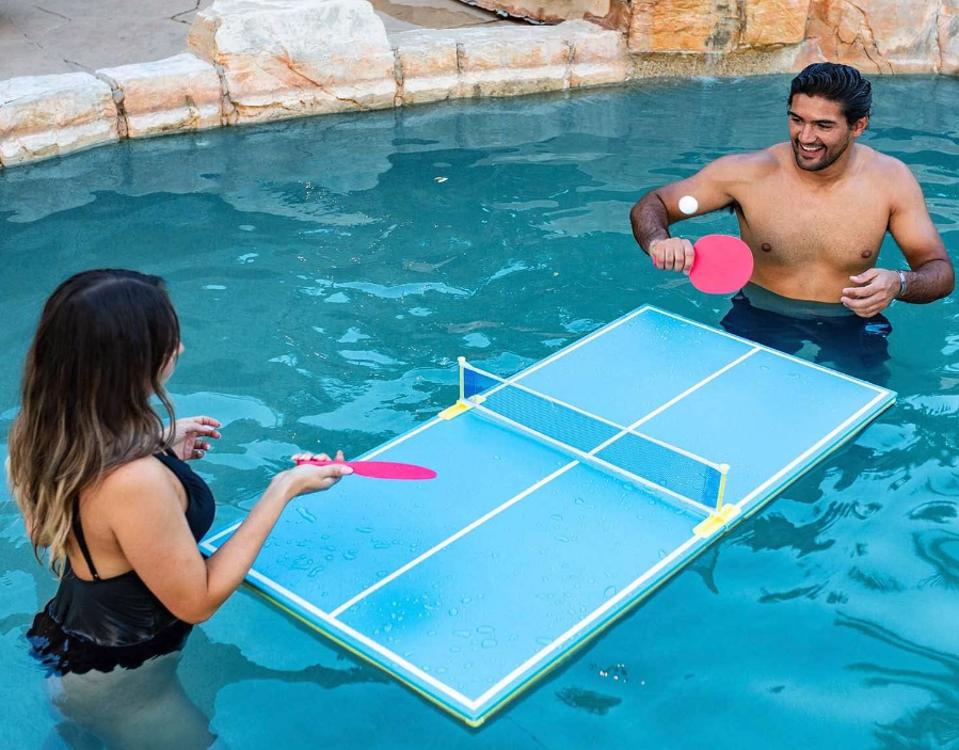 A couple in a pool using the PoolCandy Floating Table Tennis Game Toy