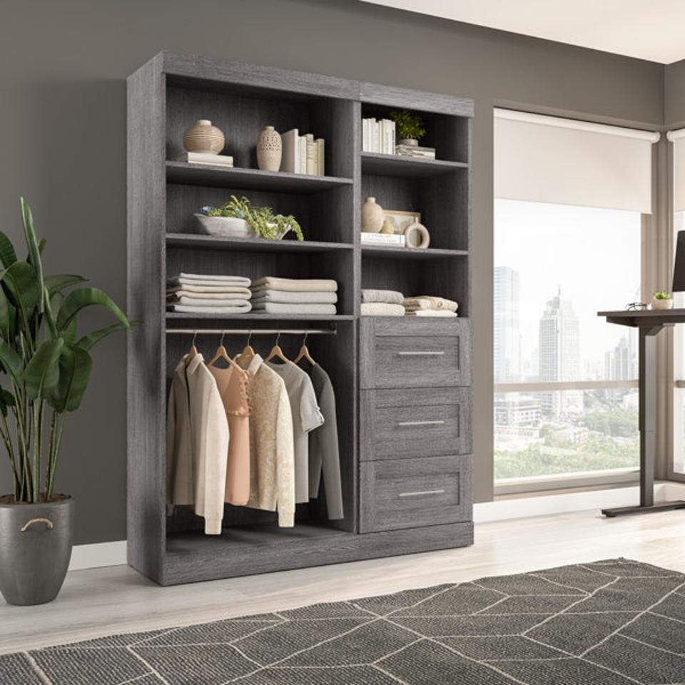 Wade Logan® Arlex 61W Closet Organizer with Drawers  featured in a bedroom and filled with clothes and decor accessories