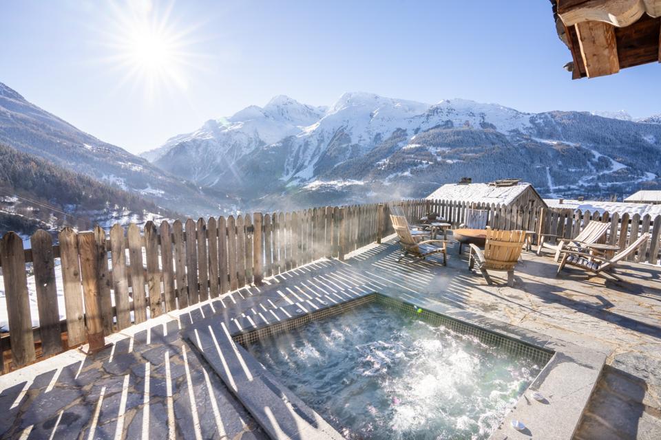 A hot tub on a back patio in the mountains