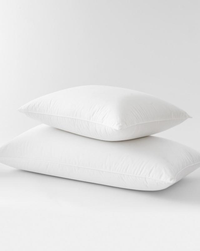 Two down pillows stacked on top of each other on a white background.