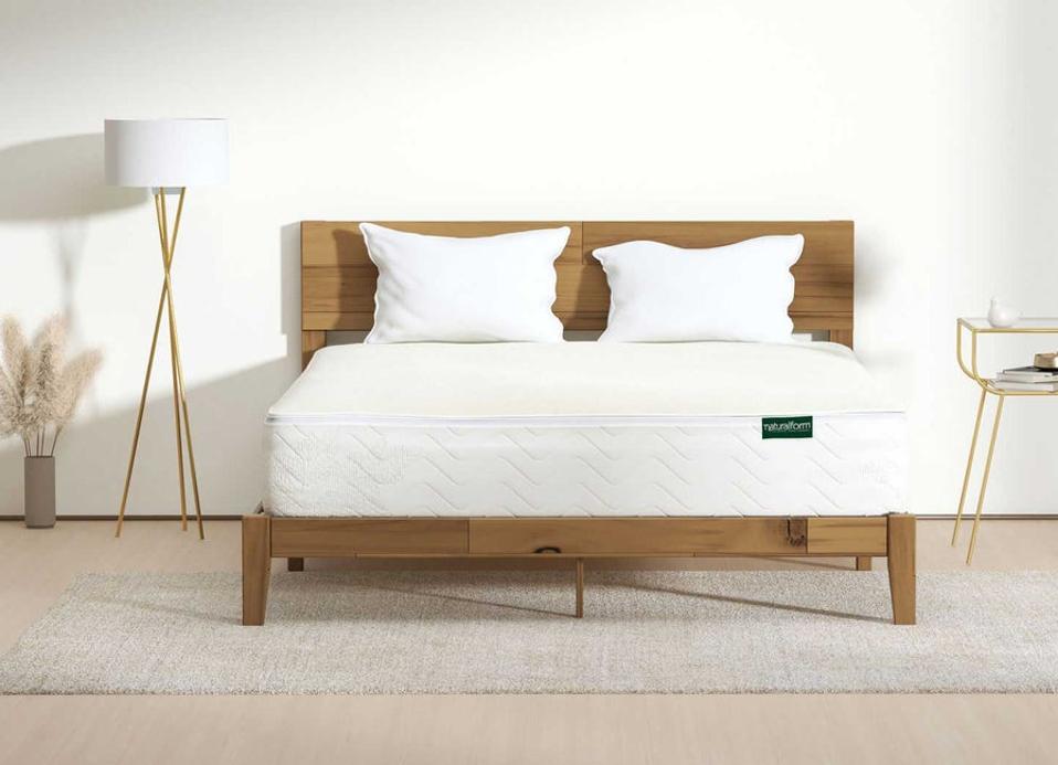 Refresh Mattress on a wood bed frame in a white bedroom. 