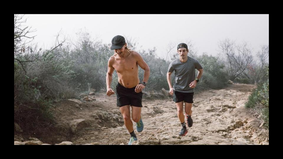 Two men running on a dirt trail