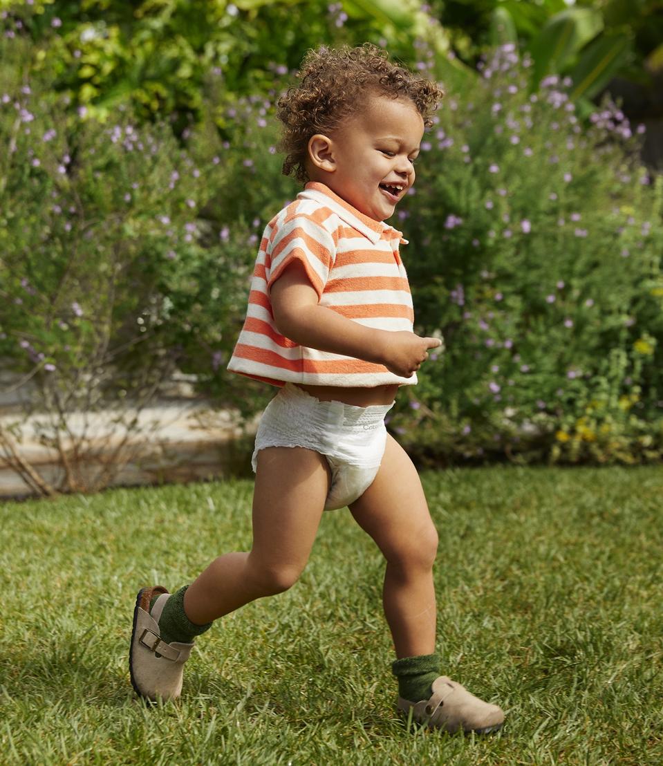 Toddler boy running outside while wearing Coterie "The Pant" pull-up style diaper