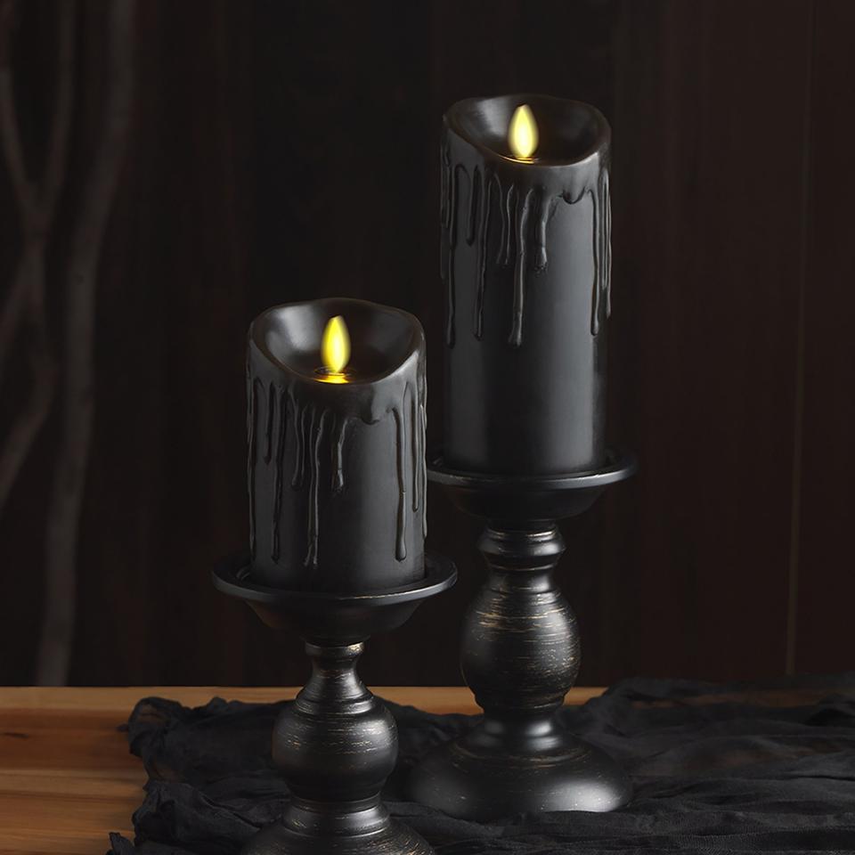 A pair of West Elm Wax Drip Flameless Pillar Candles in black