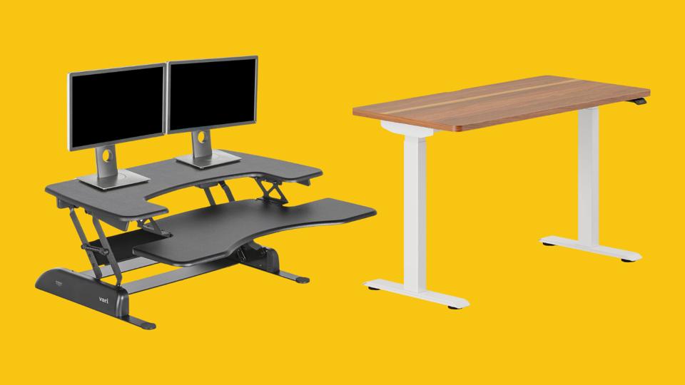 A black standing desk converter and a bamoboo standing desk on a yellow background 