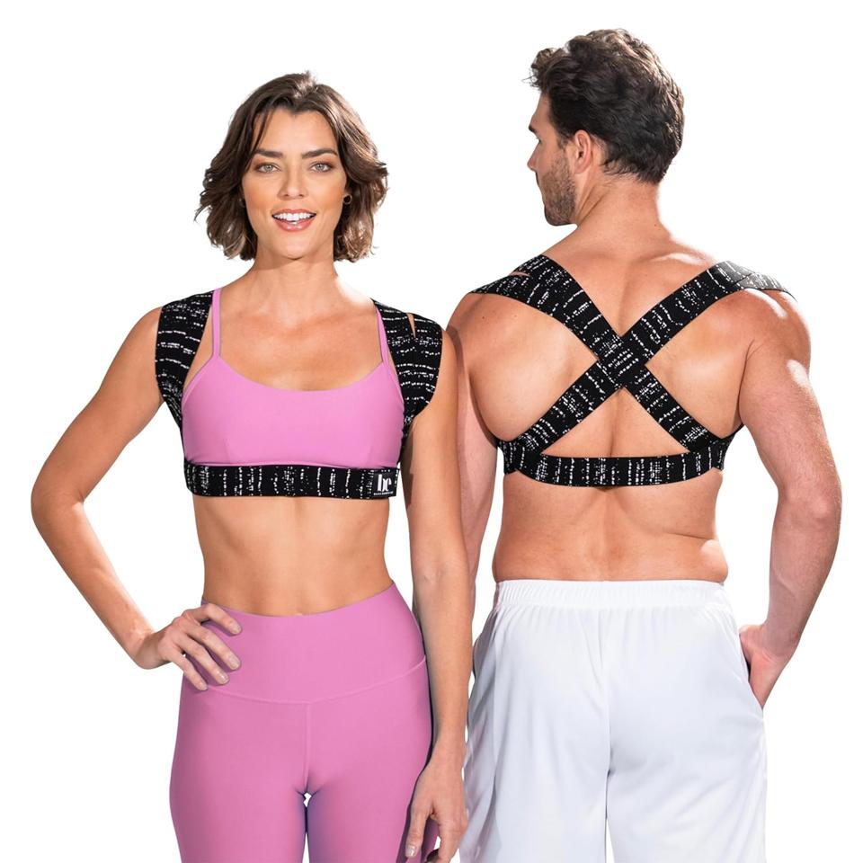 A man in white shorts and a woman in pink leggings and a sports bra wear the BackEmbrace Posture Corrector