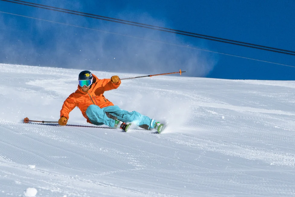 A man skiing on a hill wearing Stio gear