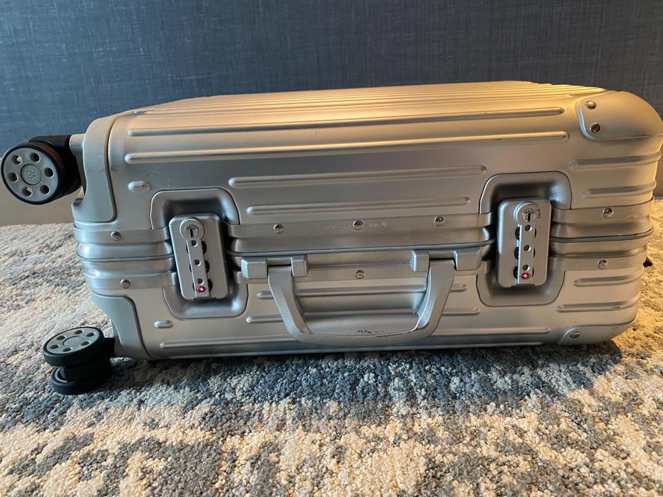 An aluminum suitcase on a carpet.