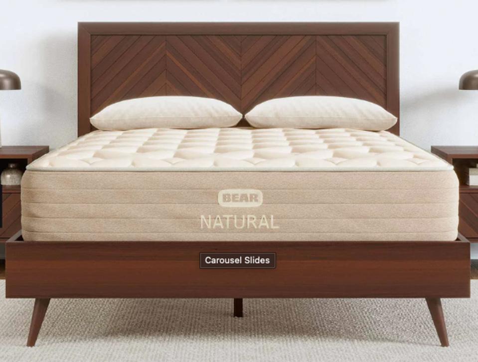 The Bear Natural mattress on a dark wood bed frame. 