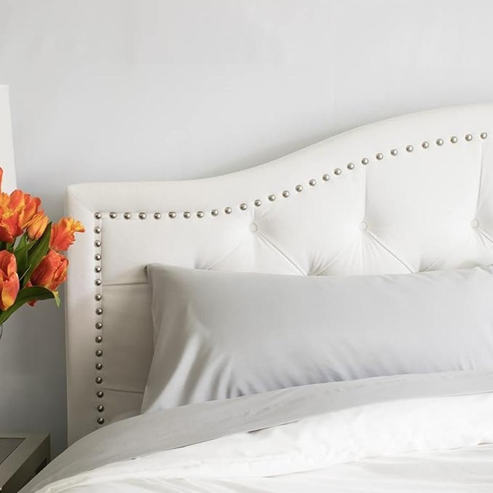 Peachskin Sheet Set on a bed with a studded white headboard.