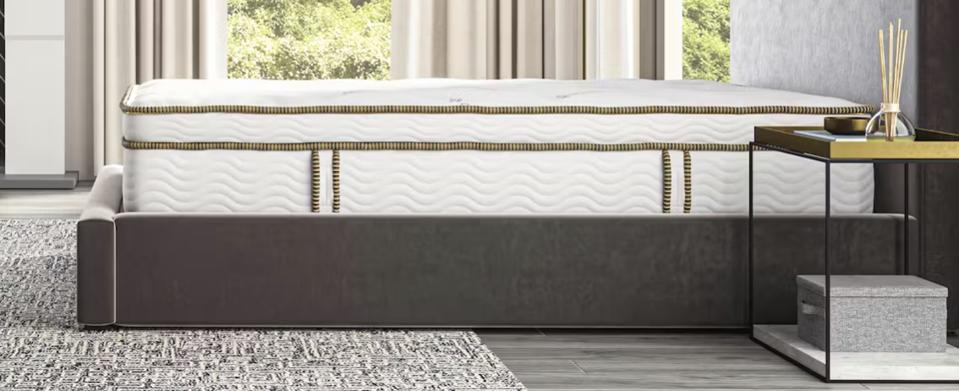 The Saatva Latex Hybrid mattress on a grey bed frame.