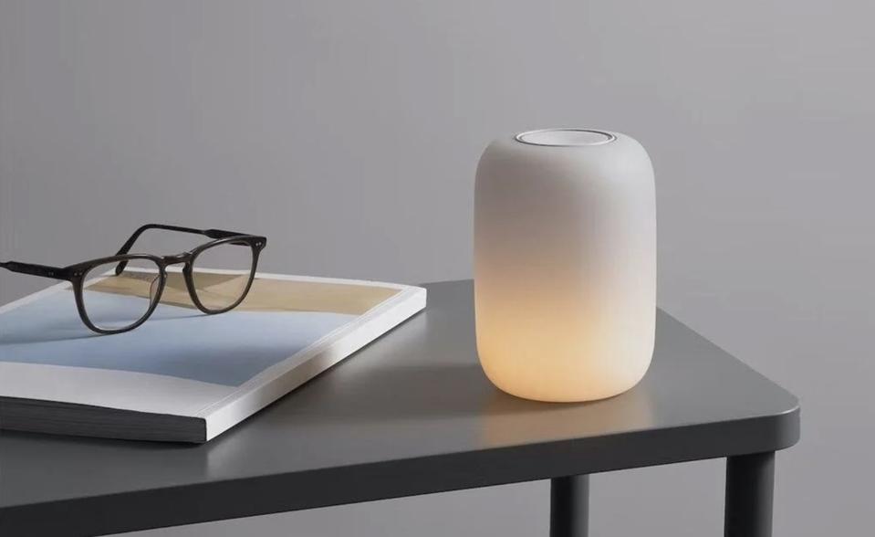 The Glow Light on a table next to a pair of glasses and a book. 