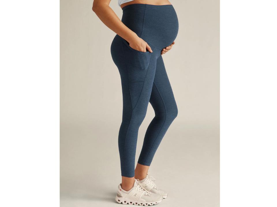 pregnant woman wearing blue Spacedye Love the Bump Maternity Pocket Midi Legging on beige bg