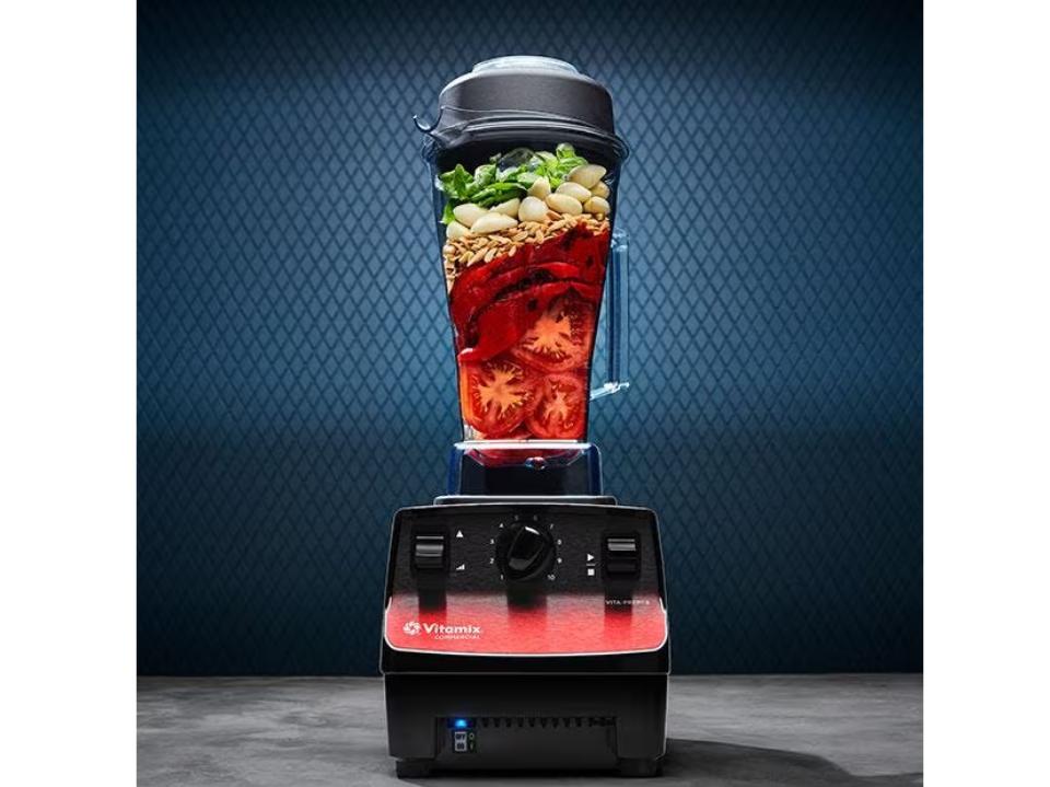 photo of Vitamix Vita-Prep 3 blender filled w/ tomates lettuce seeds against blue background