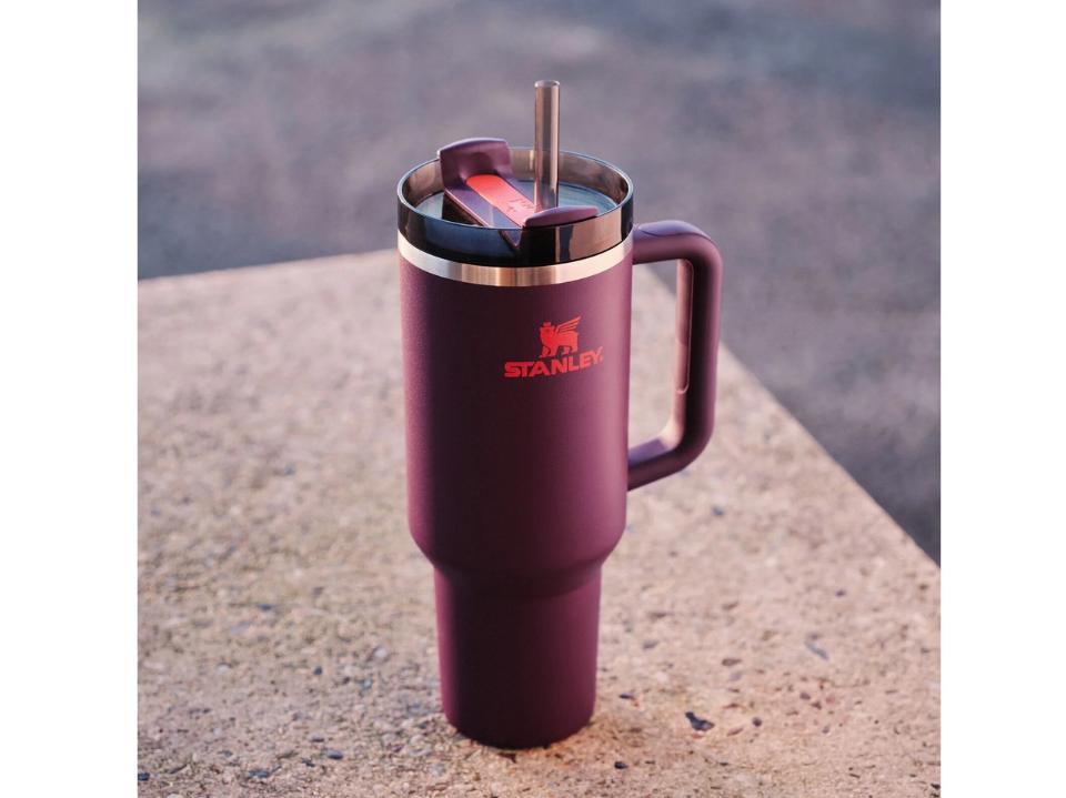 maroon Stanley Quencher H2.0 FlowState tumbler on speckled marble counter against gray bg